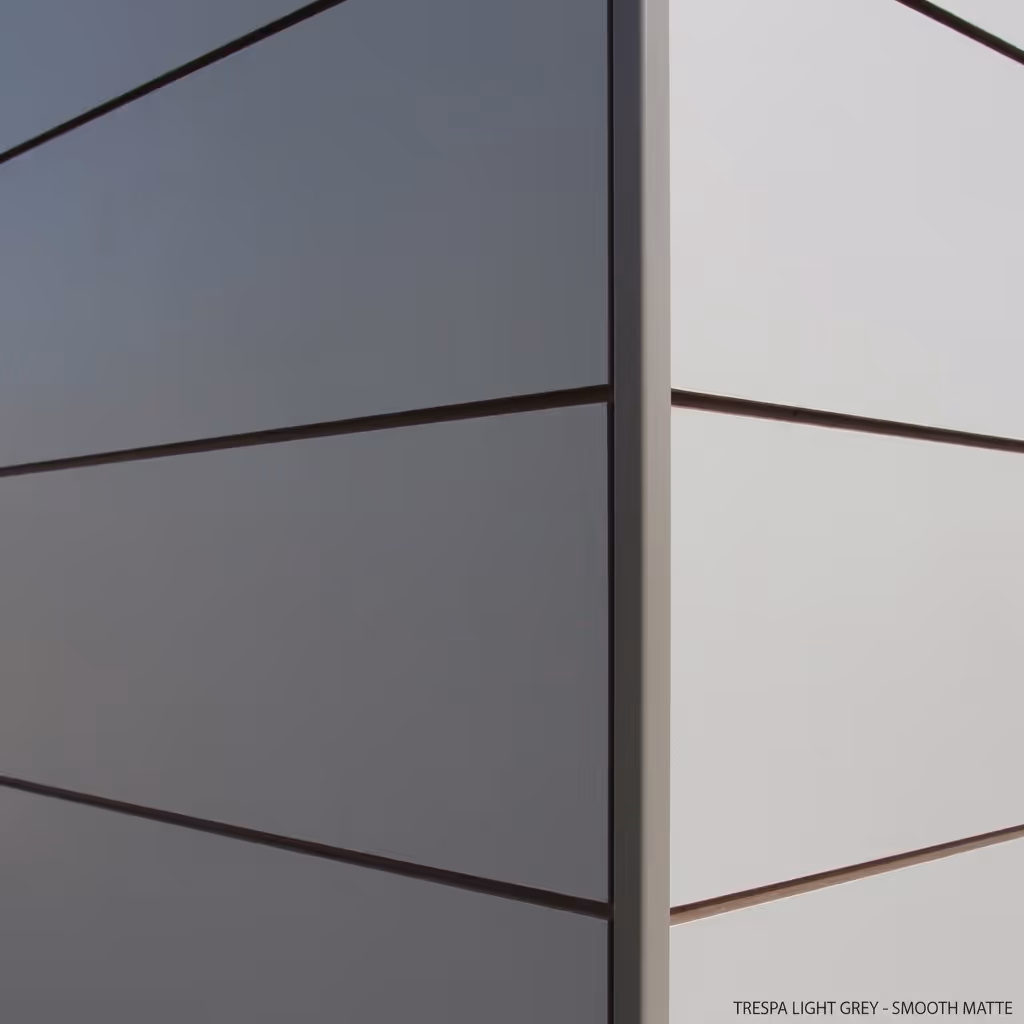 Close-up van een hoek van een gebouw met gladde matte wandpanelen in lichtgrijs en wit.